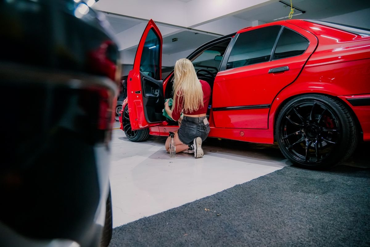 Detailing specialist cleaning car interior door panel